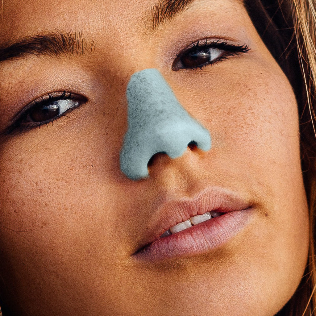 Close up shot of girl with blue reef-safe, eco-friendly SPF formula Nöz Sunscreen on nose